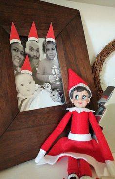 an elf is sitting in front of a photo frame