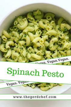 spinach pesto pasta in a white bowl with a green stripe around the edges