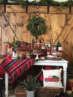 a christmas display in front of a wooden wall with plaid and pine wreaths on it