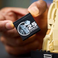 a hand holding a lego piece with the number 25 on it