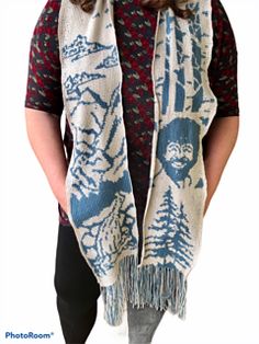 a woman wearing a scarf with an image of a man in the woods on it