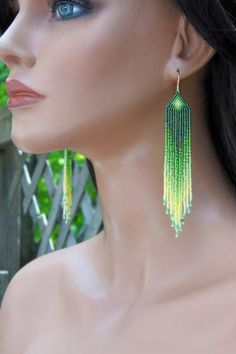 a mannequin head with green earrings on it