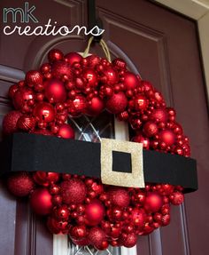 a red christmas ornament wreath hanging on a door