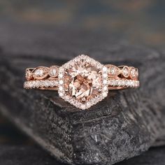 an engagement ring with a pink diamond surrounded by white diamonds on top of a rock