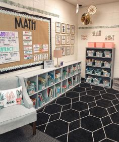 a room filled with lots of books on shelves next to a blue chair and black rug