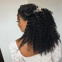 the back of a woman's head with long curly hair and a tiara