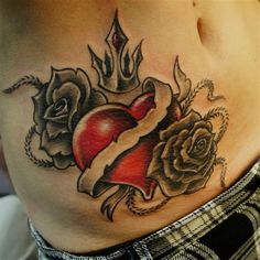 a woman's stomach with tattoos and roses on it