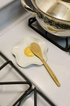 an egg is on the stove with a wooden spoon