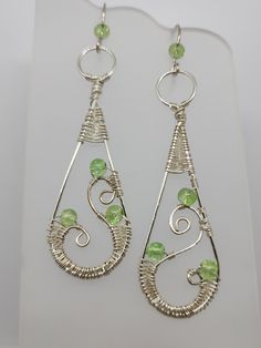 Silver artistic wire wrapped with green glass beads Green Teardrop Beaded Earrings With Wire Wrap, Green Teardrop Beaded Earrings With Wire Wrapped Detail, Green Teardrop Wire Wrapped Beaded Earrings, Green Wire Wrapped Teardrop Beaded Earrings, Nickel-free Green Metal Beaded Earrings, Green Wire Wrapped Metal Earrings, Green Teardrop Nickel-free Chandelier Earrings, Green Teardrop Chandelier Earrings Nickel Free, Handmade Green Metal Chandelier Earrings