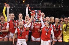 the women's soccer team celebrates with their trophy