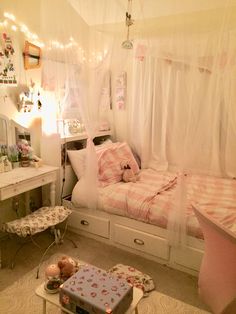 a bedroom with a bed, desk and mirror in it's center area that has lights strung from the ceiling