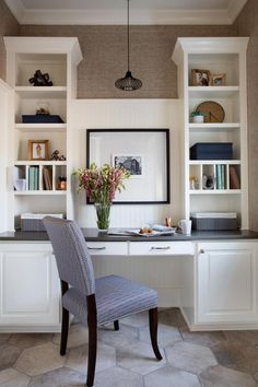 a chair sitting in front of a desk with bookshelves