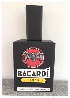 a bottle of bacardi liquor sitting on top of a table next to a white wall