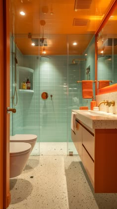 a bathroom with a toilet, sink and shower in it's glass walled area