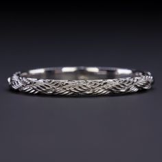 a silver braided ring on a black background