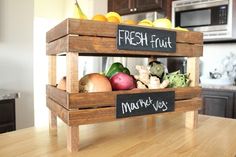 a wooden crate filled with fresh fruit on top of a kitchen counter