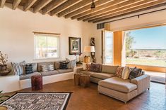 a living room filled with furniture and large windows