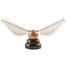 an owl figurine with white wings and gold ball on it's head