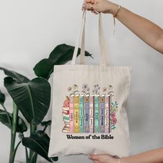 a woman is holding a bag that says women of the bible with books on it