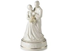 a wedding cake topper with a bride and groom figurine holding each other