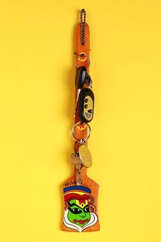 the key chain has many different items attached to it, and is hanging on a yellow wall