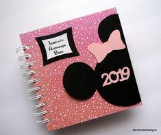 a pink and black notebook with minnie mouse on it