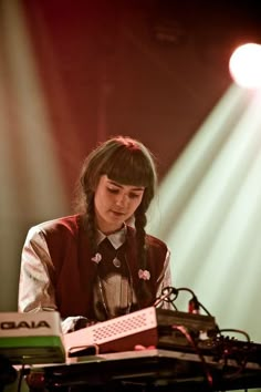 a woman standing at a keyboard on top of a stage