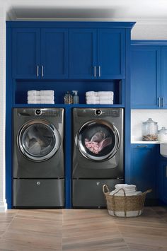 a washer and dryer in a room with blue cabinets