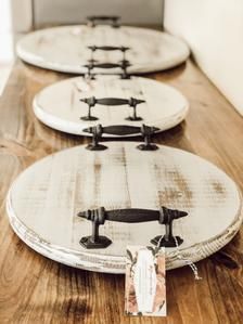 three surfboards sitting on top of a wooden table with tags attached to the boards