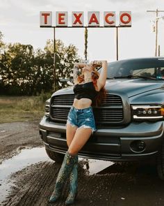 a woman sitting on the hood of a truck