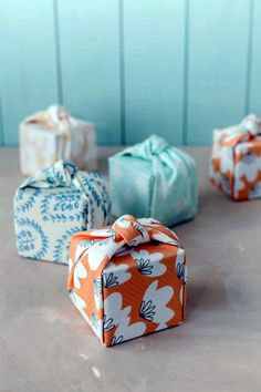 four wrapped gift boxes sitting on top of a table