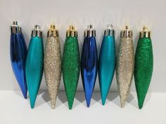 blue and green christmas ornaments are lined up