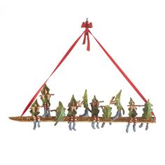 a christmas ornament hanging from a red ribbon with elves on it's back