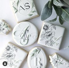 four decorated cookies with the initials and flowers on them