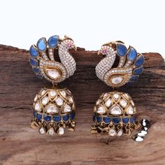 Our breathtaking Peacock Motif Statement Earring, adorned with fine quality Moissanite and a captivating Blue stone that exudes elegance and sophistication. Meticulously crafted in 925 Silver, this earring mirrors the authenticity of Indian Polki style, accentuated by high carat gold-plated silver. The omega hook and push-back closure ensure a secure and robust stud, making it an exquisite choice for weddings or evening soirees. Elevate your festive ensemble or gift this remarkable Diwali present to yourself or a loved one. Gross Weight: 43.78 gms Dimensions: 52 x 25mm Explore more exquisite pieces at our [Etsy Shop](https://www.etsy.com/in-en/shop/TempusGems). Explore more in our shop: [TempusGems](https://www.etsy.com/in-en/shop/TempusGems) Packaging and Shipping We take great care to en Elegant Chandbalis With Peacock Design For Diwali, Diamond Cutdana Earrings For Reception, Kundan Earrings With Peacock Design For Weddings, Fusion Style Peacock Design Earrings For Wedding, Elegant Sterling Silver Earrings With Peacock Design, Fusion Style Wedding Earrings With Peacock Design, Fusion Wedding Earrings With Peacock Design, Blue Cutdana Earrings For Wedding, Elegant Blue Peacock Design Jewelry