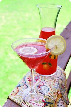 two glasses filled with liquid sitting on top of a wooden table