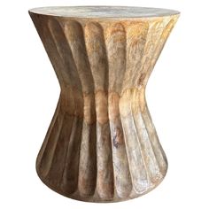 an old wooden table that has been turned into a vase with wavy lines on it