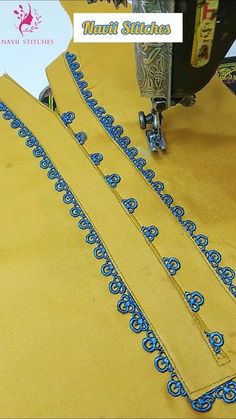 the sewing machine is working on some yellow material with blue designs and words that read, navi stitchs