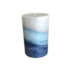 a blue and white candle holder on a white background with water in the bottom right corner