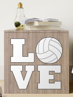 a wooden box with the word love written on it and a volleyball ball next to it