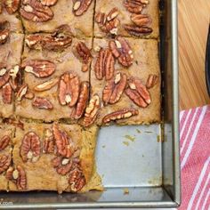 a pan filled with pecan squares on top of a wooden table