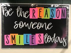 a sign that says be the reason someone smiles today