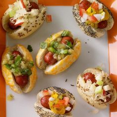 six hot dogs with toppings on them sitting on an orange and white platter