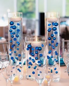 blue and white centerpieces with candles on a table