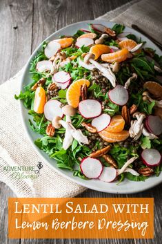 a salad with oranges, radishes and pecans on a white plate