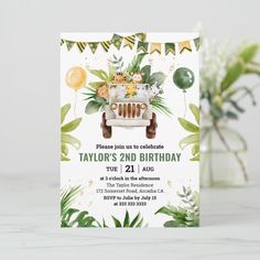 a birthday card with an image of a car and jungle leaves on it, in front of a vase filled with flowers