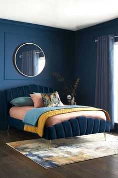 a bedroom with blue walls and a bed in the middle, along with a rug on the floor