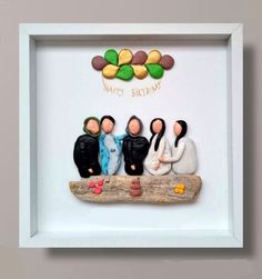 a group of people sitting on top of a piece of wood in a white frame