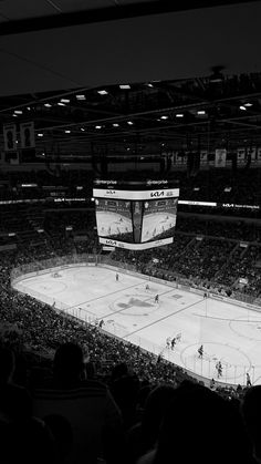 an empty hockey stadium filled with people watching the game in black and white, at night