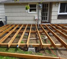 a wooden deck being built in front of a house